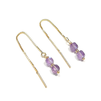 Boucles d'oreilles chaînes réglables en argent 925 doré à l'or fin 24 carats ornées de pierres fines d'améthyste.   L'améthyste, pierre de sérénité, équilibre et tempérance, facilite la méditation, renforce l'intuition et symbolise la sagesse et la force.
