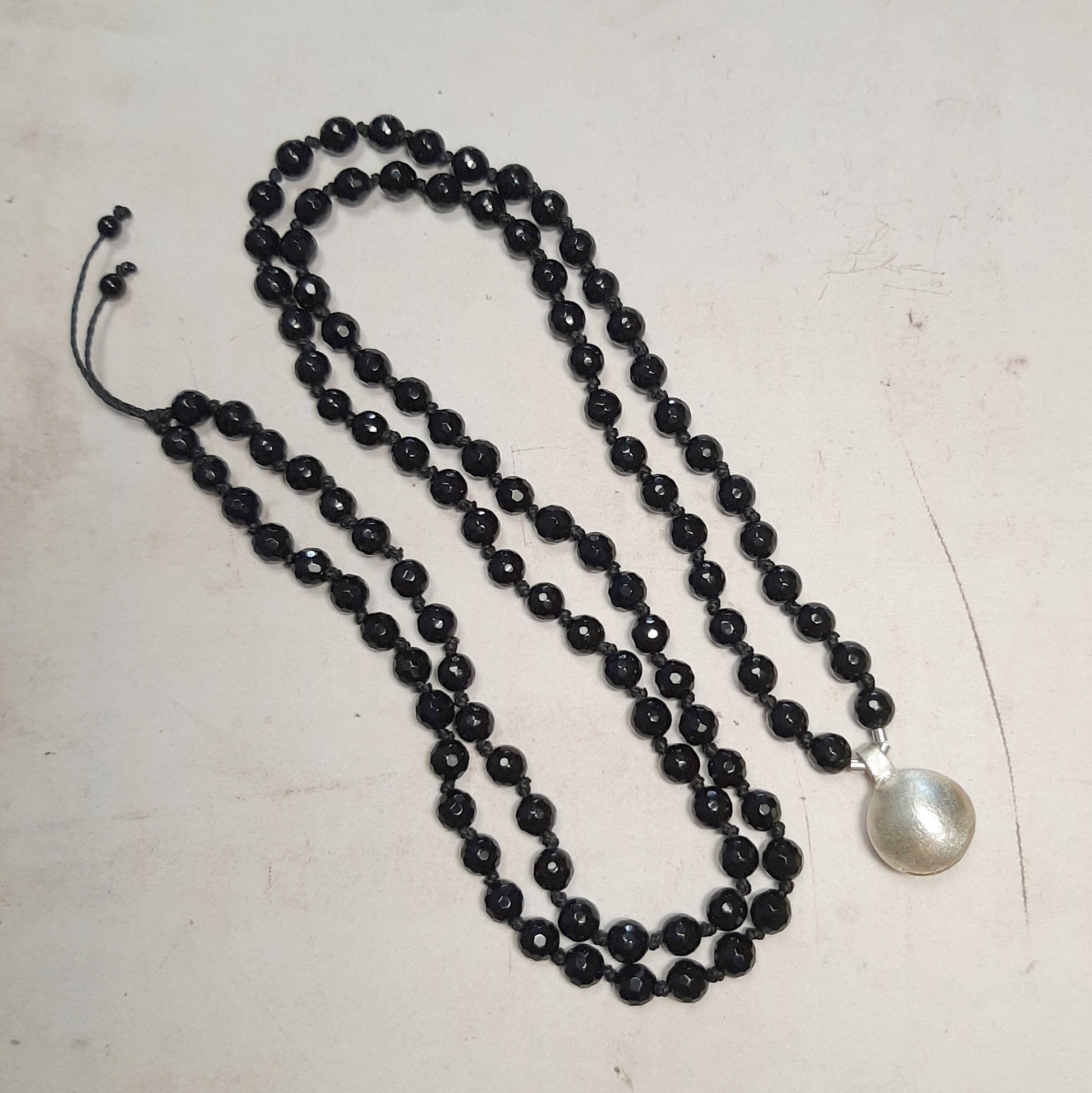 Le mala, compagnon de méditation, unit ses 108 perles au son cristallin de l’appeleur d’anges. Ce sautoir incarne la rencontre entre la sagesse intérieure et la protection spirituelle, un talisman à porter chaque jour comme un rappel de sérénité.