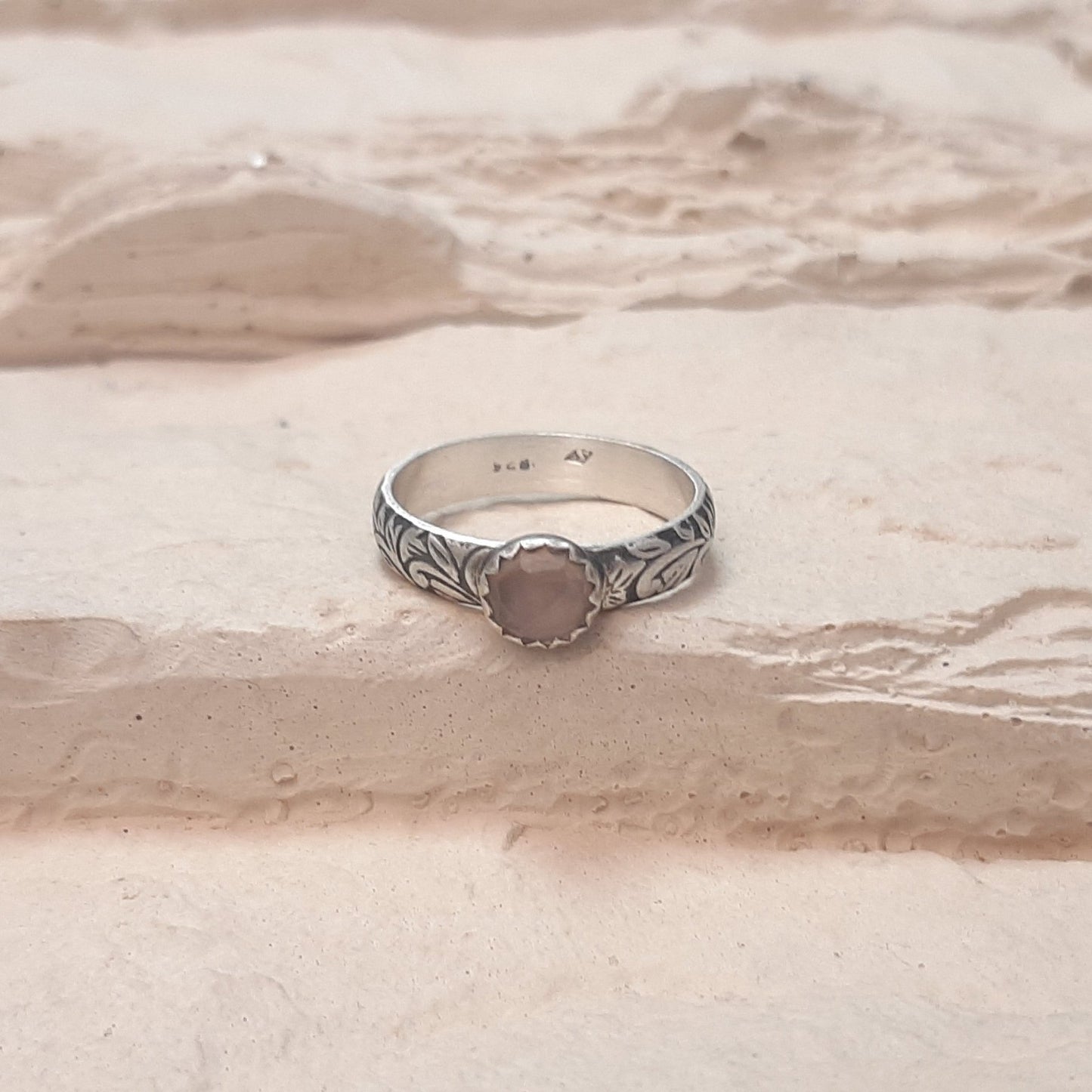 La Bague Calcédoine Rose Tropicália est un bijou artisanal en argent massif, orné d'une pierre naturelle de calcédoine rose. Son design ethnique unique, gravé de motifs floraux et feuillus, incarne à la fois élégance et spiritualité. La calcédoine rose est reconnue pour ses propriétés apaisantes, ce qui en fait un choix idéal pour ceux recherchant harmonie et beauté dans leurs accessoires. Cette bague allie tradition et modernité, parfaite pour les amateurs de bijoux faits main.