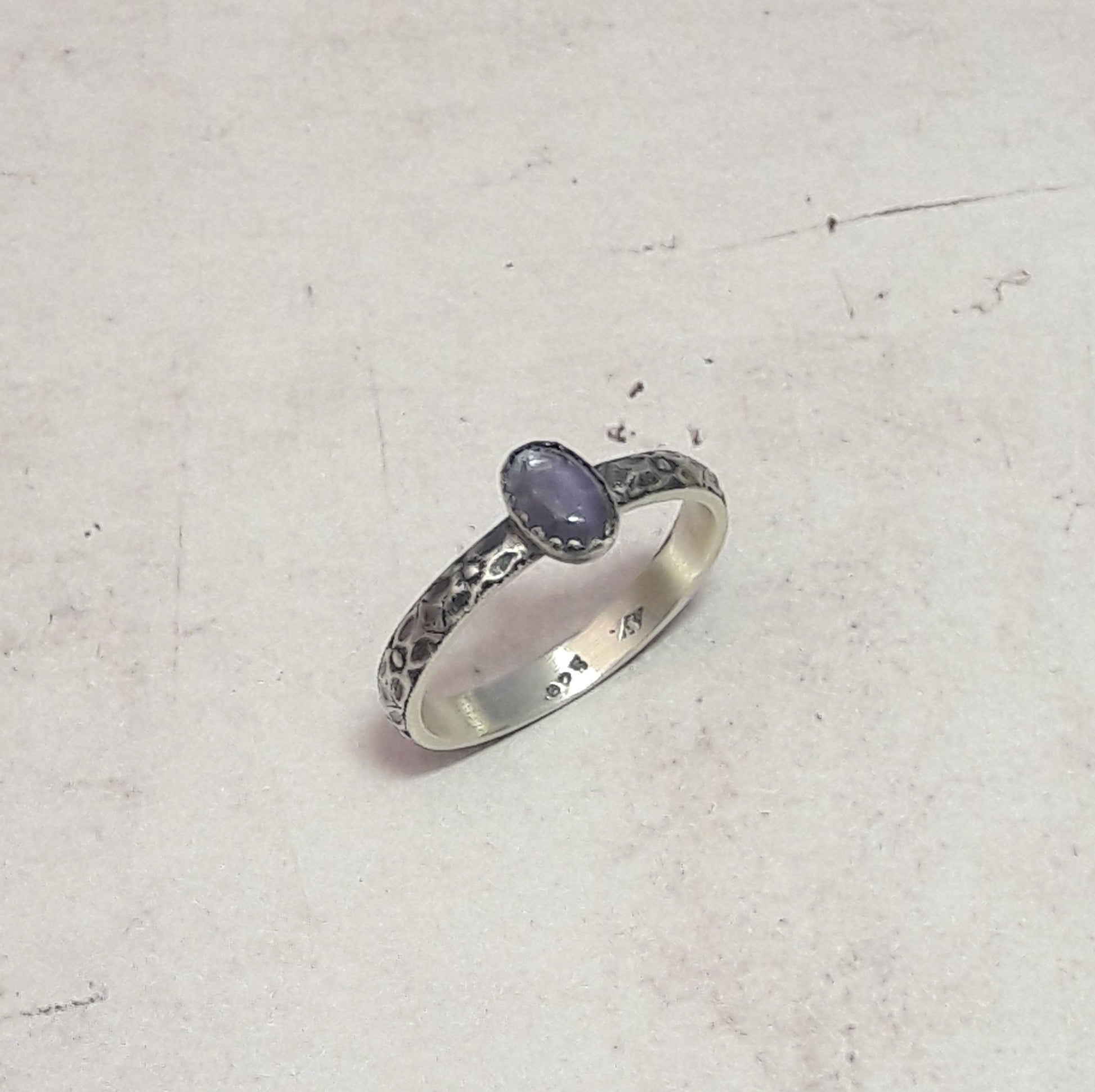  Cette bague ethnique en argent massif est ornée d'une pierre naturelle d'iolite, connue pour sa belle teinte bleue-violette. Avec ses motifs floraux gravés à la main, elle offre une touche délicate et romantique, idéale pour les amateurs de bijoux sophistiqués et uniques. La dimension de l'iolite est de 6x4 mm, et la largeur de l'anneau est d'environ 2,9 mm. Chaque pièce est fabriquée avec soin en France, garantissant une qualité artisanale et un bijou durable.