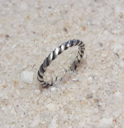 Bague torsadée fabriquée en argent massif patiné, alliant élégance et rusticité. Son design artisanal offre une touche d'originalité tout en restant intemporel, convenant aussi bien aux hommes qu'aux femmes. Avec une largeur d’environ 2,6 mm, ce bijou distinctif reflète une esthétique authentique, parfaite pour symboliser un engagement, une amitié, ou pour offrir à quelqu'un qui apprécie les pièces uniques et pleines de caractère.