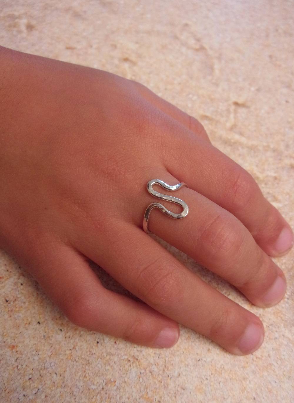 Cette bague pour fille ou femme en argent massif martelé présente une texture unique obtenue grâce à un travail artisanal minutieux. Conçue avec un argent de haute qualité, elle offre une durabilité exceptionnelle et un éclat durable. Sa largeur de 1,5 mm en fait un accessoire discret, élégant, et raffiné.