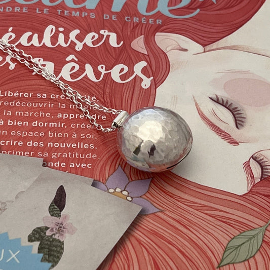 Le sautoir bola en argent massif martelé, orné de pierres fines, est un bijou traditionnel de grossesse inspiré des coutumes indonésiennes. Porté sur le ventre, il émet un tintement doux et harmonieux à chaque mouvement, offrant un effet apaisant pour le bébé. Sa conception en argent véritable et son design délicat en font un accessoire à la fois esthétique et symbolique, idéal pour accompagner la future maman tout au long de la grossesse.