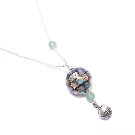 Bola de Grossesse en Argent, Nacre et Aventurine
Ce bola est composé d'une chaine en argent 925/1000, un pendentif en nacre abalone et aventurine avec une petite cloche argent 925/1000.Les pierres sont naturelles, leurs couleurs et reflets peuvent varier.