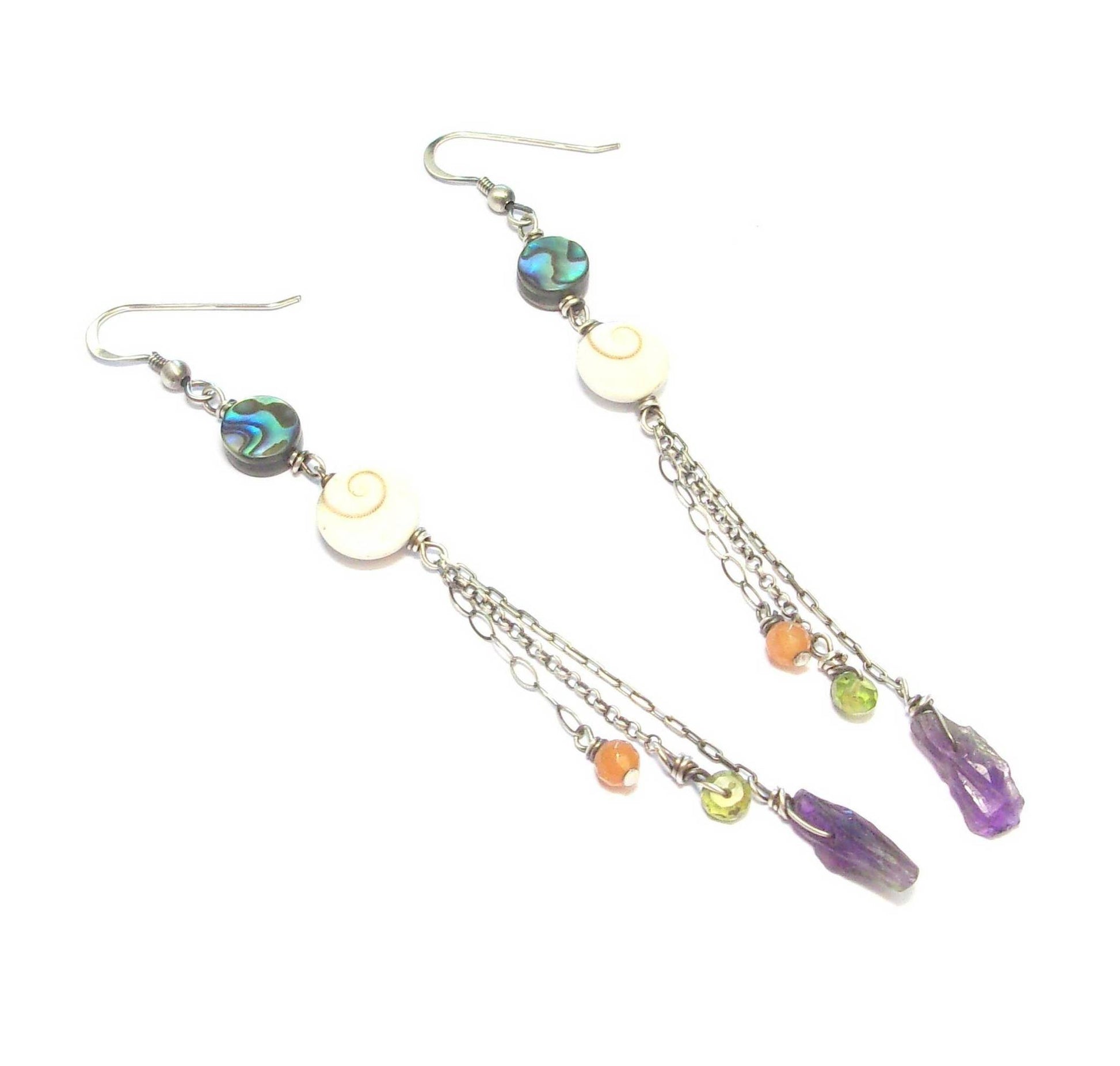 Boucles d'oreilles ethniques longues en argent patiné noir, ornées de coquillages et de pierres naturelles telles que l'améthyste, le péridot et l'aventurine. Les pierres et coquillages, étant naturels, présentent des variations de forme et de couleur. La longueur est de 10 cm.