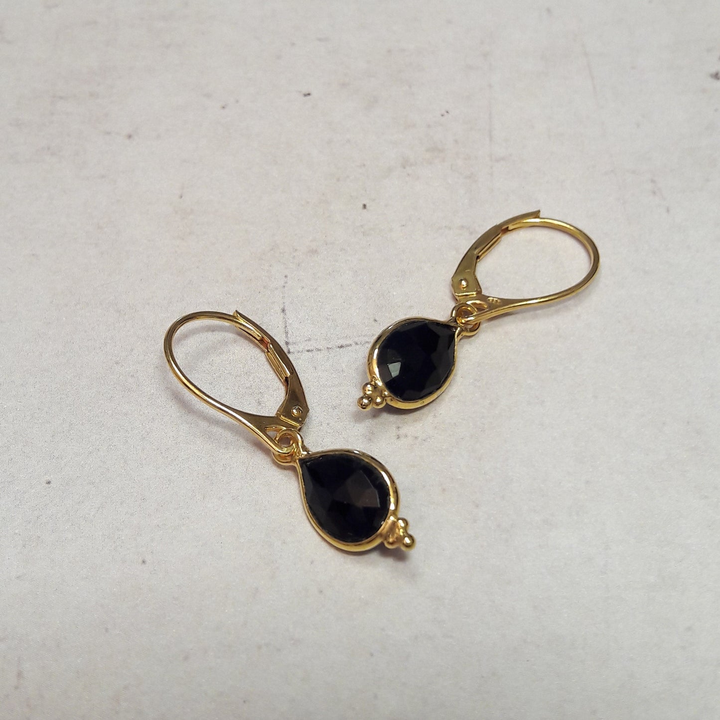Boucles d'oreilles dormeuses en argent 925 doré à l'or fin 24 carats, ornées de pierres naturelles d'onyx. Design élégant et intemporel ajoutant une touche de sophistication à toute tenue.