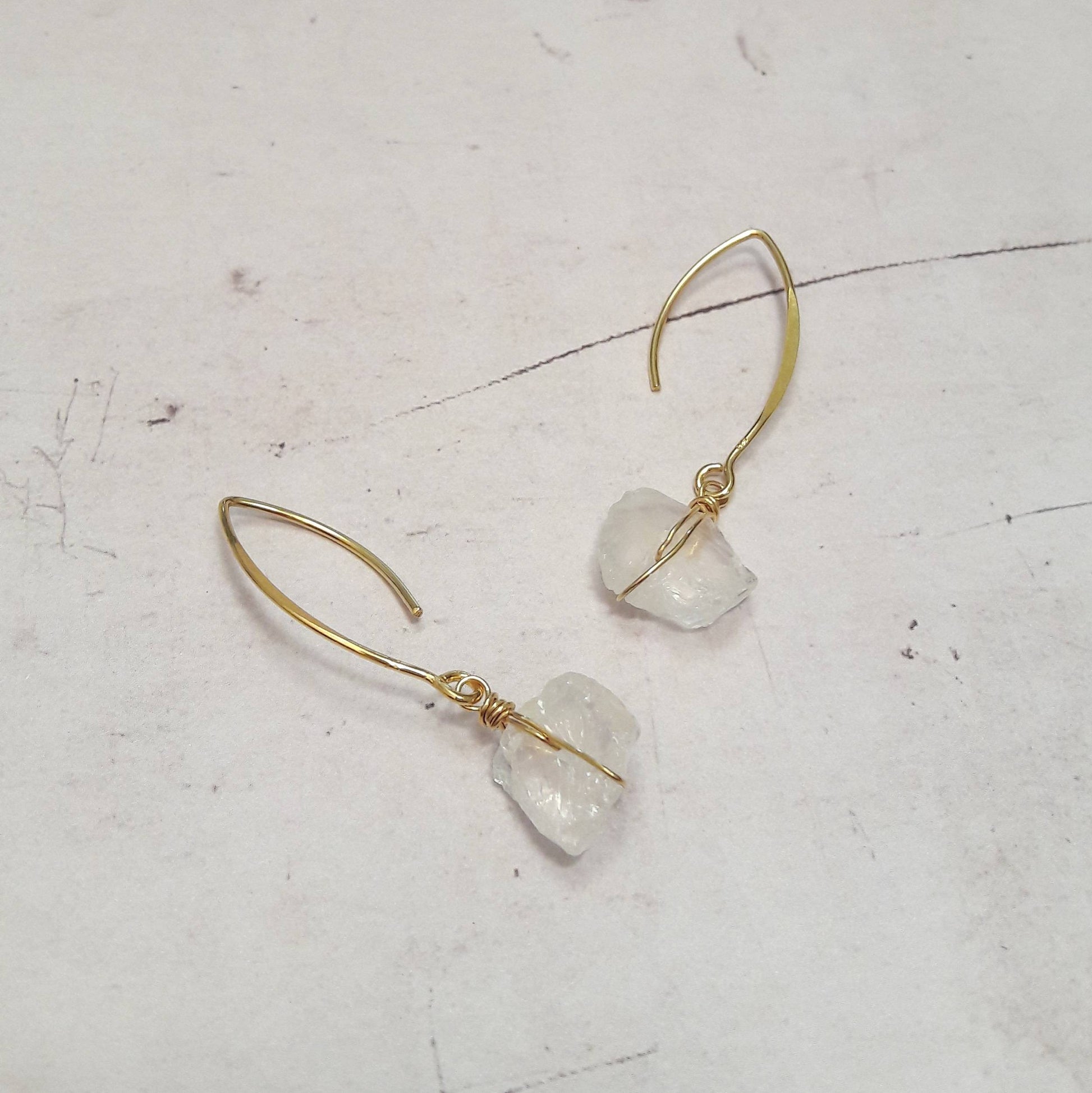 Boucles d'oreilles en argent 925 doré à l'or fin, ornées de pierres naturelles brutes de cristal de roche. Les pierres, en raison de leur caractère naturel, peuvent présenter des variations de couleurs et de formes, rendant chaque paire véritablement exclusive.  Longueur : 5.5 cm environ  ✨Le cristal de roche, en lithothérapie, est réputé pour apporter vitalité et réconfort. Il possède la capacité de recevoir, d'émettre et d'amplifier les énergies.