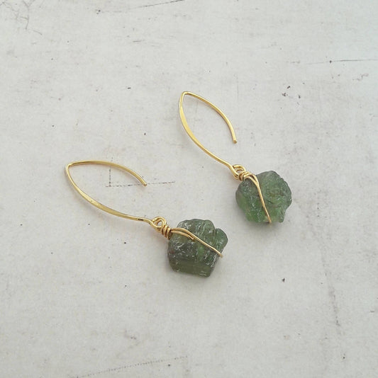 Boucles d'oreilles en argent 925 doré à l'or fin, ornées de pierres naturelles brutes de grenat vert. Les pierres, naturelles, peuvent présenter des variations légères de couleurs et de formes.  Longueur : 5.5 cm environ  ✨Le grenat vert, pierre énergisante, est réputé pour apporter détermination, dynamisme et courage à son porteur.