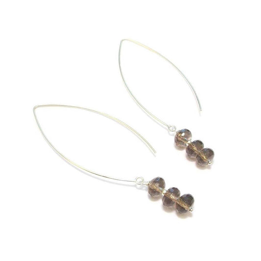 Boucles d’oreilles longues en argent massif ornées de pierres naturelles de quartz fumé facetté. Longueur : 8,0 cm environ.   Le quartz fumé est reconnu pour ses propriétés puissantes, aidant à surmonter le stress et les moments difficiles. Cette pierre atténue la peur et apporte un calme émotionnel.