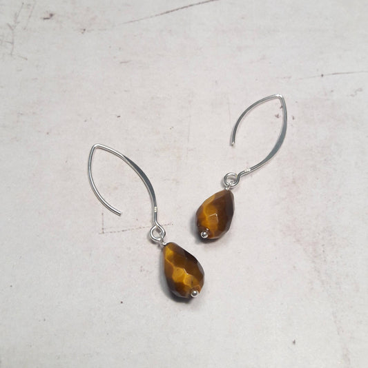 Découvrez des boucles d'oreilles longues et intemporelles fabriquées en argent 925, ornées de pierres naturelles œil de tigre. Chaque boucle d'oreille présente une longueur d'environ 4.5 cm. 