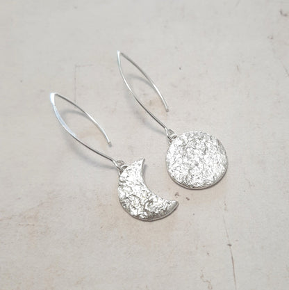 Ces boucles d'oreilles asymétriques en argent massif réticulé, représentant un croissant de lune et une pleine lune, présentent une texture organique unique.
