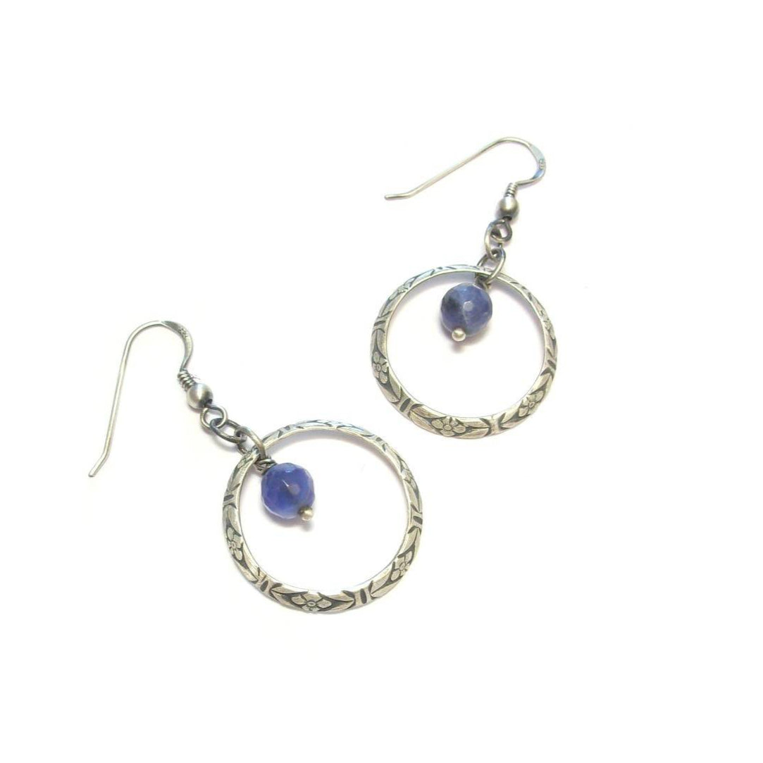 Apportez une touche d'élégance ethnique à votre style avec les boucles d'oreilles Terena en argent massif et sodalite. Ces boucles, alliant artisanat et matériaux nobles, sont idéales pour sublimer une tenue bohème chic ou pour offrir un cadeau empreint de sens.