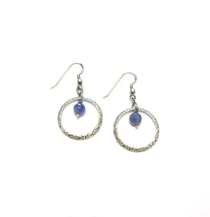 Découvrez les boucles d'oreilles Terena, une création unique en argent massif patiné et sodalite. Inspirées de l'esthétique ethnique, elles associent la brillance de l'argent 925 à la profondeur bleutée de la sodalite, pierre connue pour ses vertus apaisantes. Parfaites pour les amateurs de bijoux artisanaux et de lithothérapie, ces boucles d'oreilles apporteront une touche d'originalité et de sérénité à votre quotidien.