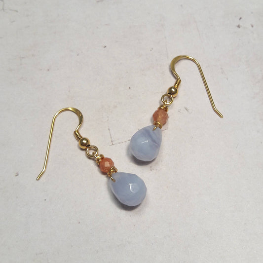 Ces boucles d'oreilles en argent 925 doré à l'or fin, ornées de pierres naturelles telles que la calcédoine bleue et la pierre de lune orange, allient simplicité et élégance. Fabriquées à la main dans le Loiret, elles mesurent environ 3,1 cm de longueur.