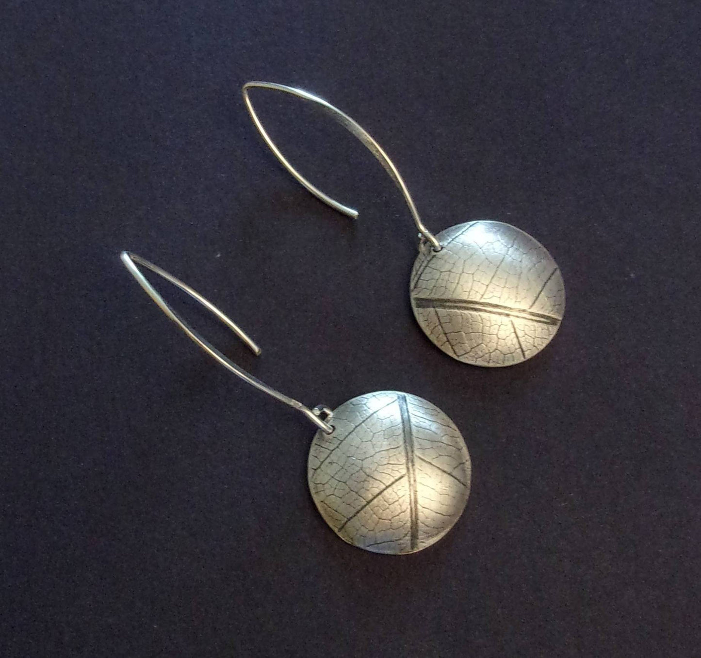 Boucles d'oreilles ethniques en argent massif gravé et patiné, avec une délicate empreinte de feuille de fruit de la passion. Chaque bijou présente une touche d'élégance naturelle et originale. La longueur est d'environ 4.6 cm et le diamètre du disque est d'environ 18 mm.