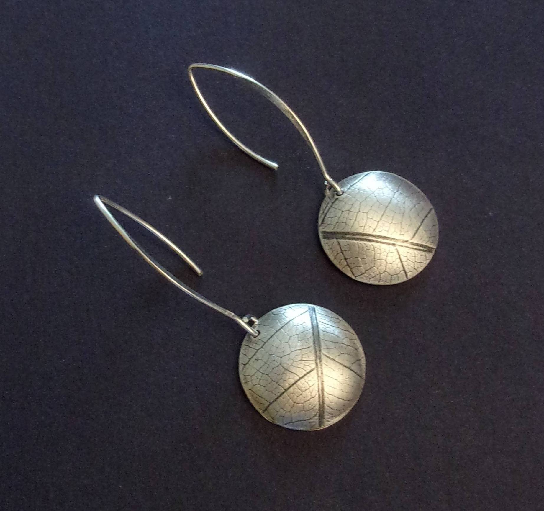 Boucles d'oreilles ethniques en argent massif gravé et patiné, avec une délicate empreinte de feuille de fruit de la passion. Chaque bijou présente une touche d'élégance naturelle et originale. La longueur est d'environ 4.6 cm et le diamètre du disque est d'environ 18 mm.