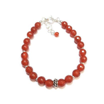 Ce bracelet élégant associe la pureté de l'argent 925 aux énergies vibrantes de la cornaline, une pierre naturelle connue pour ses vertus de courage et de vitalité. Mesurant 17 cm avec une chaînette ajustable, il est conçu pour s'adapter parfaitement à votre poignet. Chaque pierre de 6 mm est minutieusement sélectionnée et montée à la main en France, garantissant un bijou de qualité 