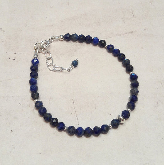 Bracelet élégant en argent 925 orné de perles de lapis-lazuli naturelles. Chaque pierre est unique, avec des nuances de bleu profond et des veines dorées caractéristiques. Longueur ajustable: 17 cm avec une chaînette d'extension. Diamètre des perles: 4 mm.

Le lapis-lazuli, pierre précieuse utilisée depuis l'Antiquité, est réputé pour ses vertus protectrices. Il apporte sérénité et courage, tout en aidant à soulager le stress. Un bijou à la fois esthétique et porteur de sens.