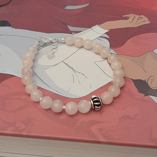 Ce bracelet délicat marie la tendresse du quartz rose, pierre de l'amour et de la paix intérieure, avec la pureté de l'argent 925. Chaque perle de quartz rose de 6 mm est soigneusement sélectionnée et assemblée à la main en France, créant un bijou qui symbolise la douceur et l'élégance. Avec une longueur de 17 cm et une chaînette ajustable, ce bracelet s'adapte à tous les poignets.