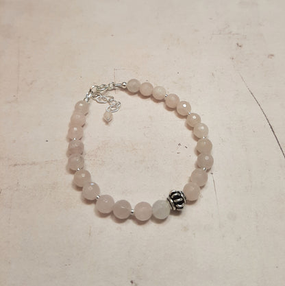 Ce bracelet délicat marie la tendresse du quartz rose, pierre de l'amour et de la paix intérieure, avec la pureté de l'argent 925. Chaque perle de quartz rose de 6 mm est soigneusement sélectionnée et assemblée à la main en France, créant un bijou qui symbolise la douceur et l'élégance. Avec une longueur de 17 cm et une chaînette ajustable, ce bracelet s'adapte à tous les poignets.