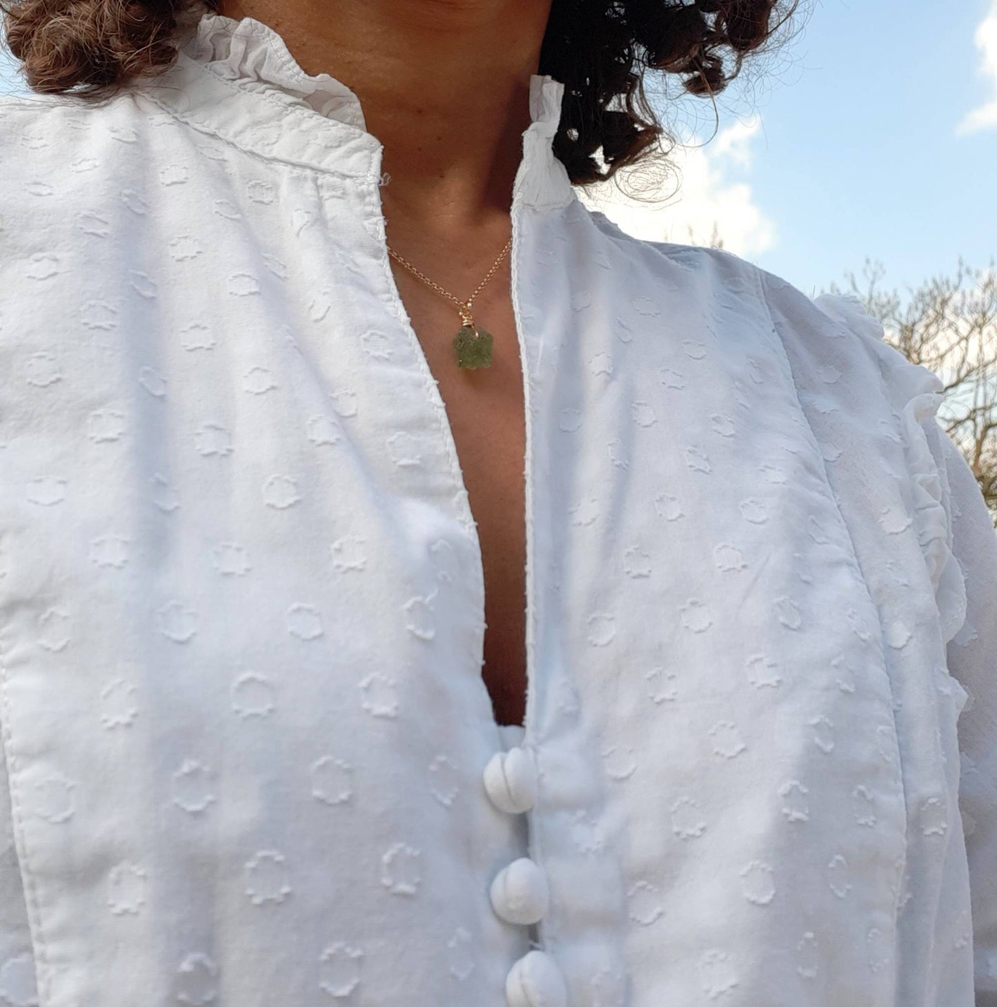 Symbole de vitalité et d'élégance, ce collier en grenat vert brut se marie avec l'argent doré pour un charme intemporel.