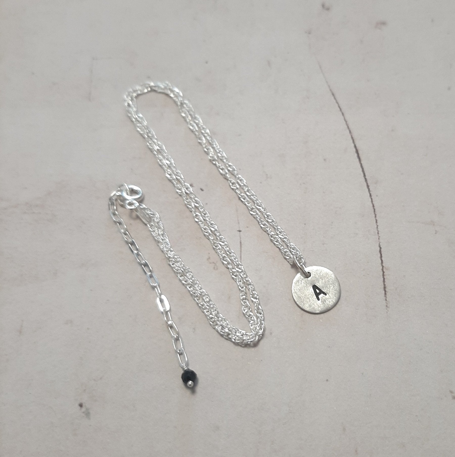 Créez un collier unique avec votre initiale gravée. Argent massif 925. Cadeau personnalisé idéal.