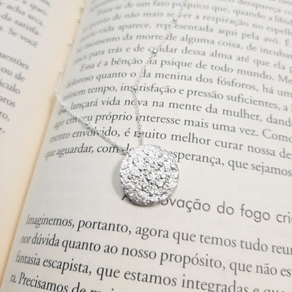 Collier avec un pendentif en forme de pleine lune en argent massif réticulé. 