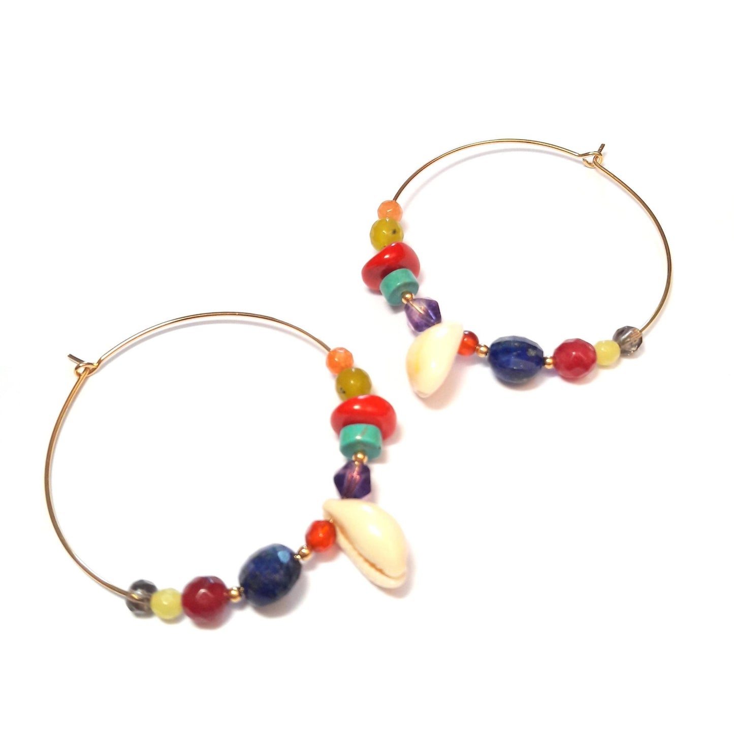 Découvrez nos créoles cauri en argent 925 doré à l'or fin 24 carats, ornées de pierres naturelles (serpentine, lapis-lazuli, améthyste…). Fait main en France avec des matériaux durables, elles sont parfaites pour ajouter une touche ethnique et élégante à vos tenues.