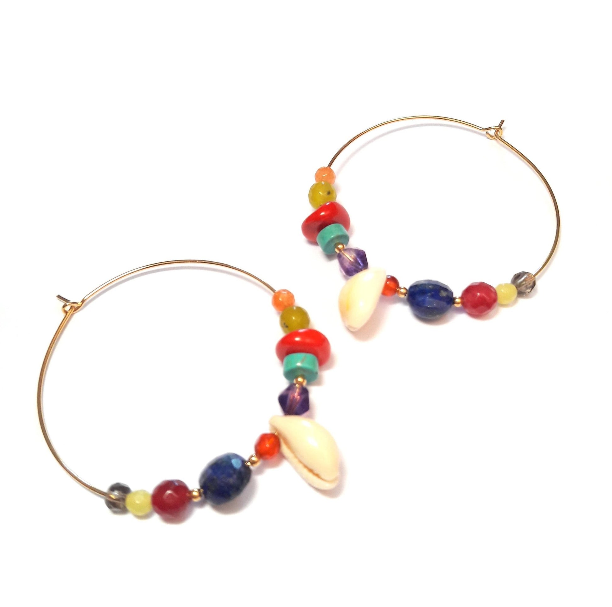Découvrez nos créoles cauri en argent 925 doré à l'or fin 24 carats, ornées de pierres naturelles (serpentine, lapis-lazuli, améthyste…). Fait main en France avec des matériaux durables, elles sont parfaites pour ajouter une touche ethnique et élégante à vos tenues.