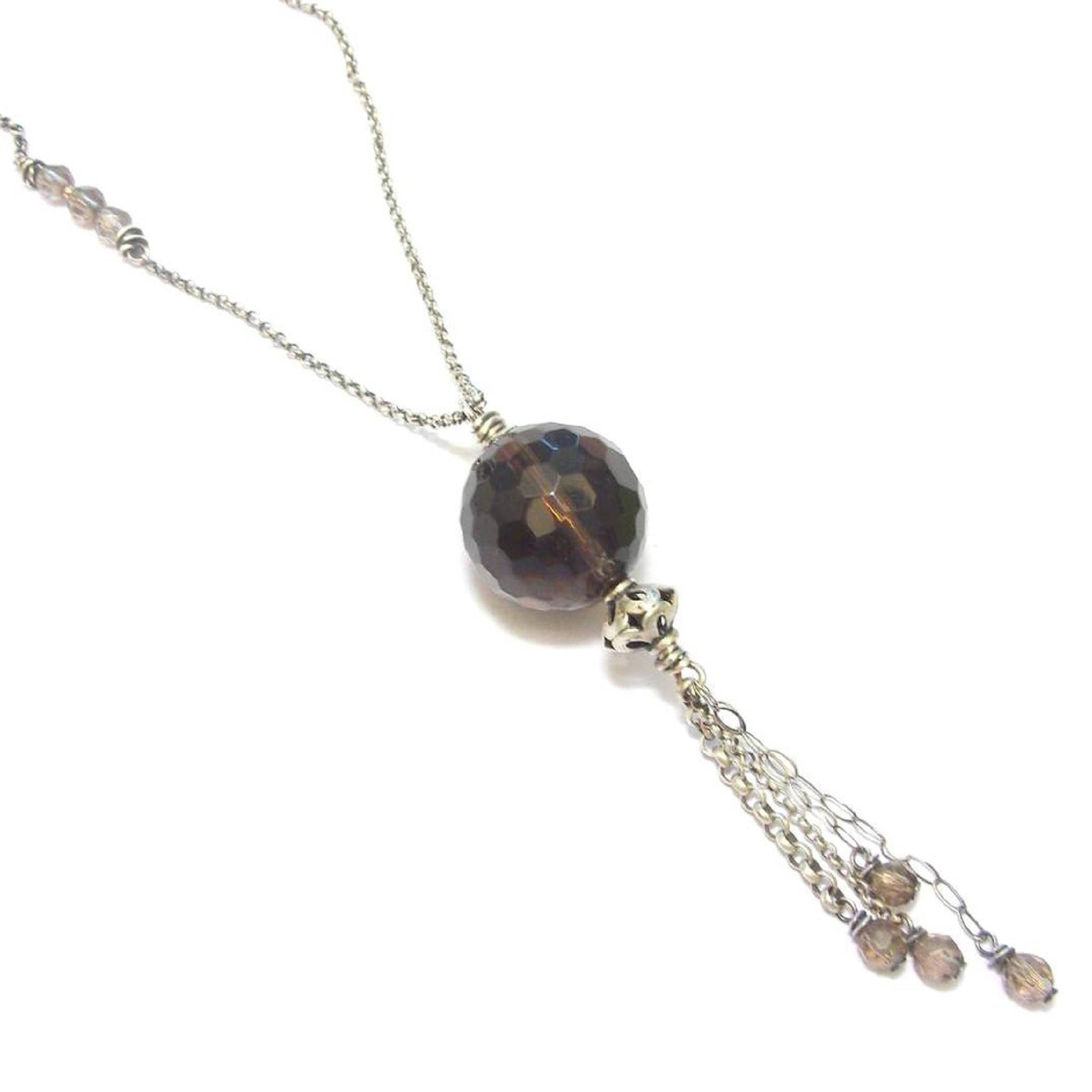 Sautoir ethnique en argent 925 patiné, orné d'un pendentif en quartz fumé, une pierre semi-précieuse aux vertus apaisantes. Ce collier long de 90 cm sans fermoir met en valeur un quartz de 18 mm, apportant à la fois élégance et bien-être. En lithothérapie, le quartz fumé aide à surmonter le stress et les moments difficiles, favorisant le calme émotionnel et la réduction des peurs.