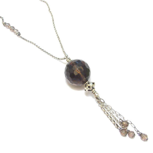 Sautoir ethnique en argent 925 patiné, orné d'un pendentif en quartz fumé, une pierre semi-précieuse aux vertus apaisantes. Ce collier long de 90 cm sans fermoir met en valeur un quartz de 18 mm, apportant à la fois élégance et bien-être. En lithothérapie, le quartz fumé aide à surmonter le stress et les moments difficiles, favorisant le calme émotionnel et la réduction des peurs.