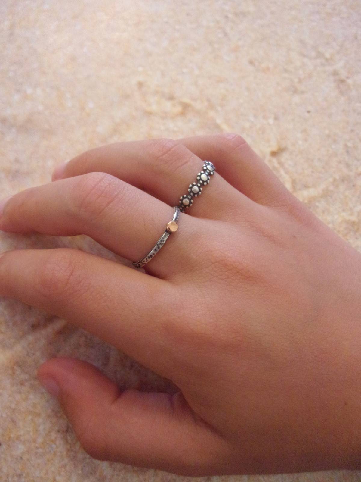 Bague fine ethnique en argent massif patiné, agrémentée d'une petite perle en or 9 carats. Son design élégant et artisanal combine l'authenticité de l'argent martelé avec l'éclat subtil de l’or, créant ainsi un bijou unique .