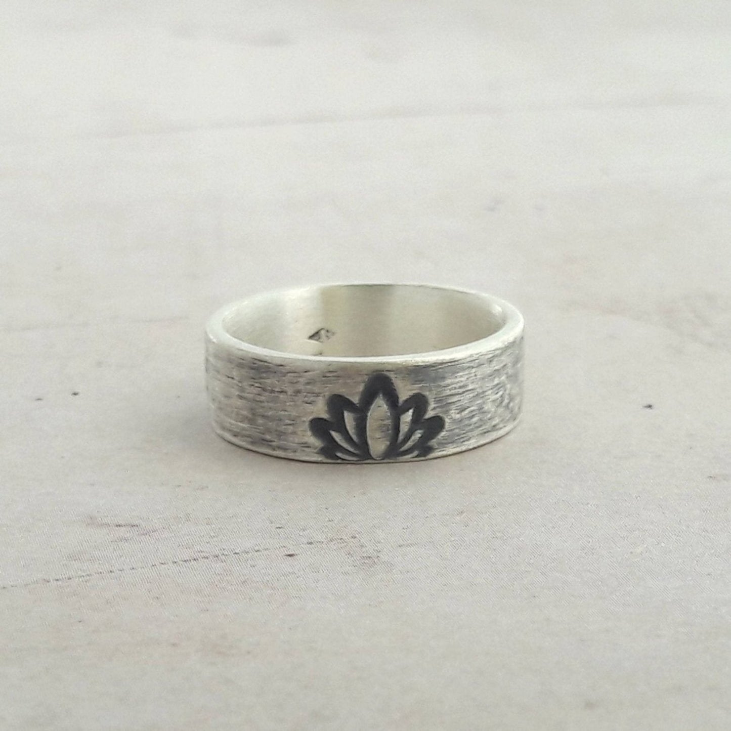 Découvrez notre bague ethnique en argent massif, ornée d'une gravure de fleur de lotus, symbole de pureté et de renouveau. Bijou artisanal unisexe, parfait pour un style spirituel et élégant.