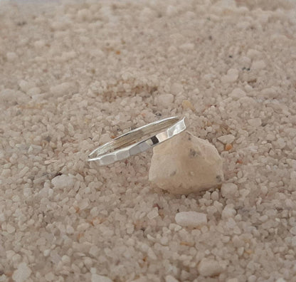 Découvrez la bague Simplicidade, une alliance fine en argent massif martelé, parfaite pour un style minimaliste et élégant. Fabriquée à la main en France, idéale pour superpositions et fiançailles. Bijoux non genrés.