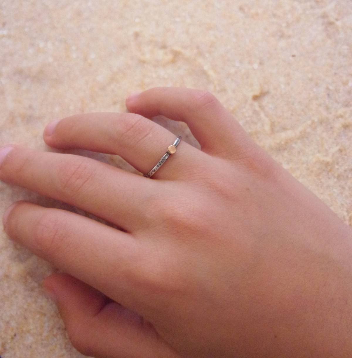 Bague fine ethnique en argent massif patiné, agrémentée d'une petite perle en or 9 carats. Son design élégant et artisanal combine l'authenticité de l'argent martelé avec l'éclat subtil de l’or, créant ainsi un bijou unique .