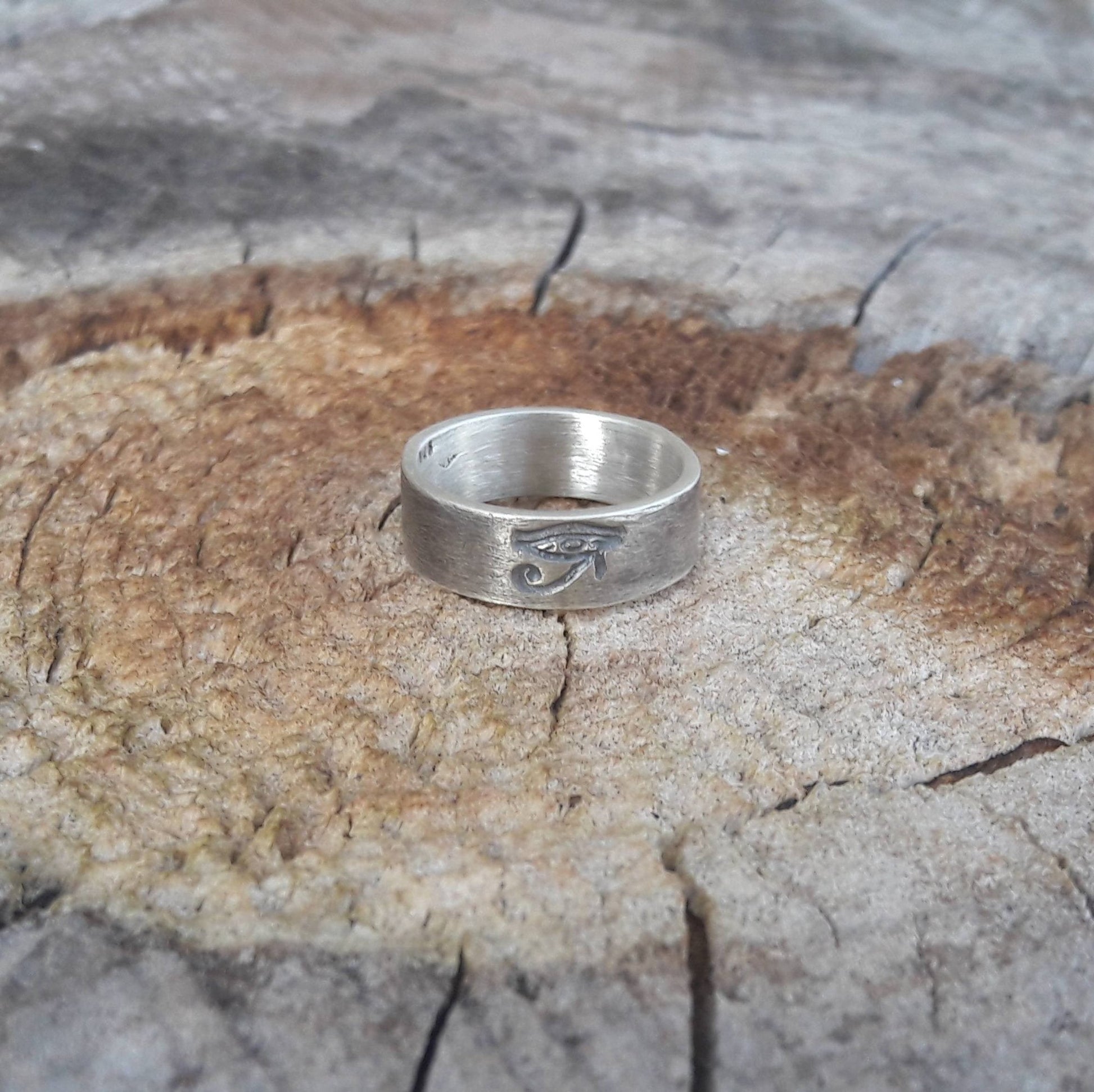 La bague fait main "Œil d'Horus" en argent massif patiné, avec une largeur d'environ 6 mm, se distingue par son design symbolique et intemporel. Unisexe, elle convient aussi bien aux hommes qu'aux femmes. L’Œil d’Horus, également appelé oudjat, est un symbole ancien de protection et de clairvoyance, souvent porté comme un porte-bonheur. 