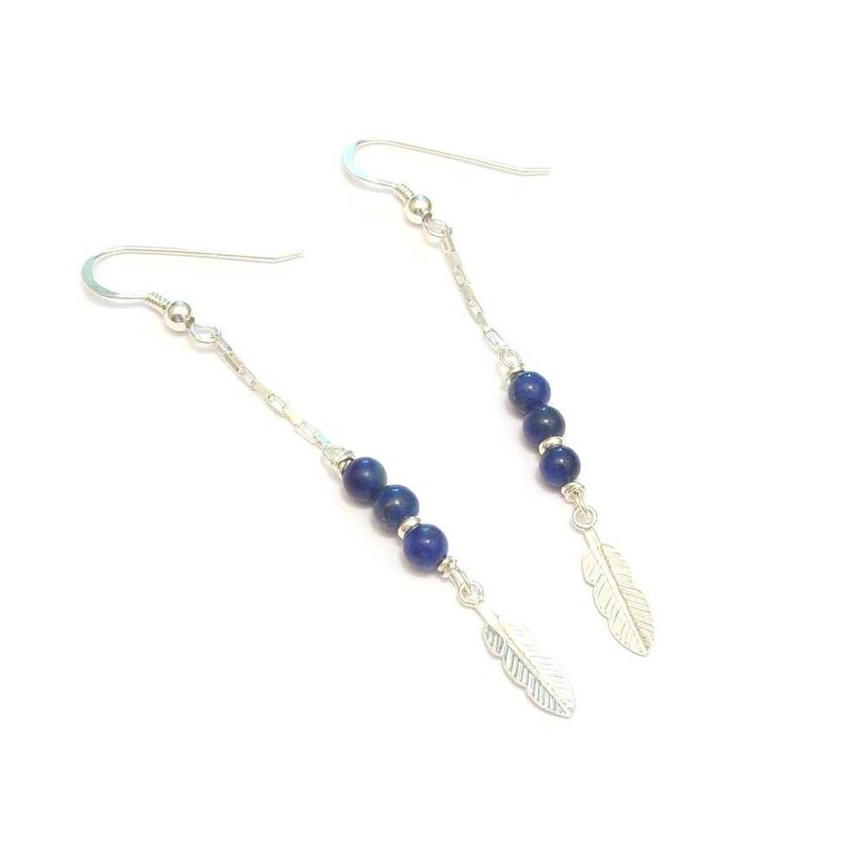 Boucles d'oreilles en argent 925 ornées de pierres naturelles de lapis-lazuli. Leur design bohème est rehaussé d'une délicate plume, symbole de légèreté et de liberté. Longueur : 6,8 cm.