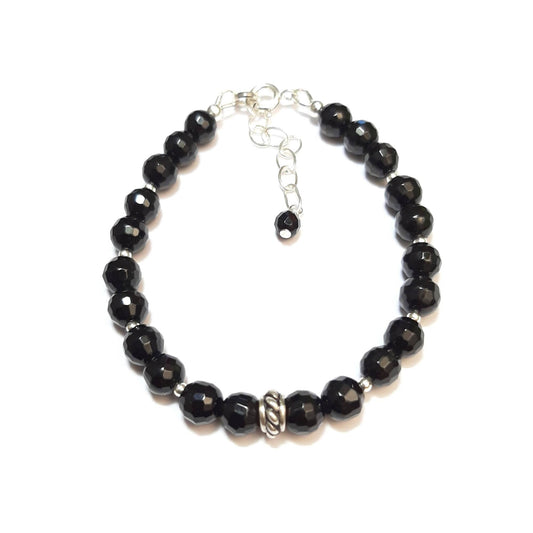 Ce bracelet élégant associe la puissance protectrice de l'onyx noir avec la brillance intemporelle de l'argent 925. L'onyx, pierre de force et de résilience, est soigneusement sélectionné pour un bijou qui incarne l'élégance et la protection. Chaque bracelet est fabriqué à la main en France, mesurant 17 cm avec une chaînette ajustable pour un confort parfait.