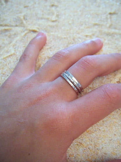 Cet ensemble de 3 bagues fines en argent massif est un mariage parfait de sophistication et de simplicité. Composé de deux bagues avec une finition martelée et d'une bague en fil torsadé, la bague Trindade offre une variété de styles pour répondre à toutes vos envies. 