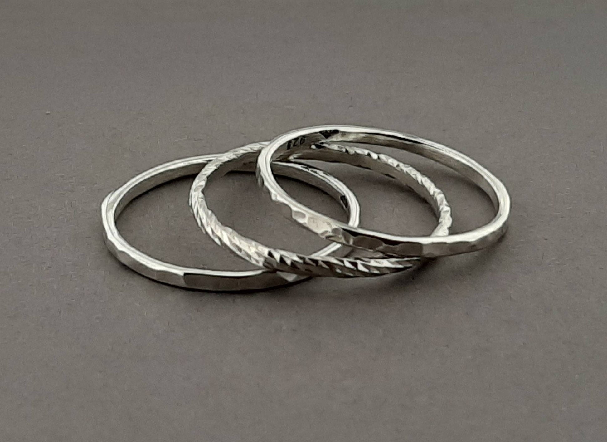Cet ensemble de 3 bagues fines en argent massif, comprenant deux bagues martelées et une torsadée, allie sophistication et simplicité. La bague Trindade peut être portée empilée ou séparément, offrant polyvalence et adaptabilité pour toutes les occasions.