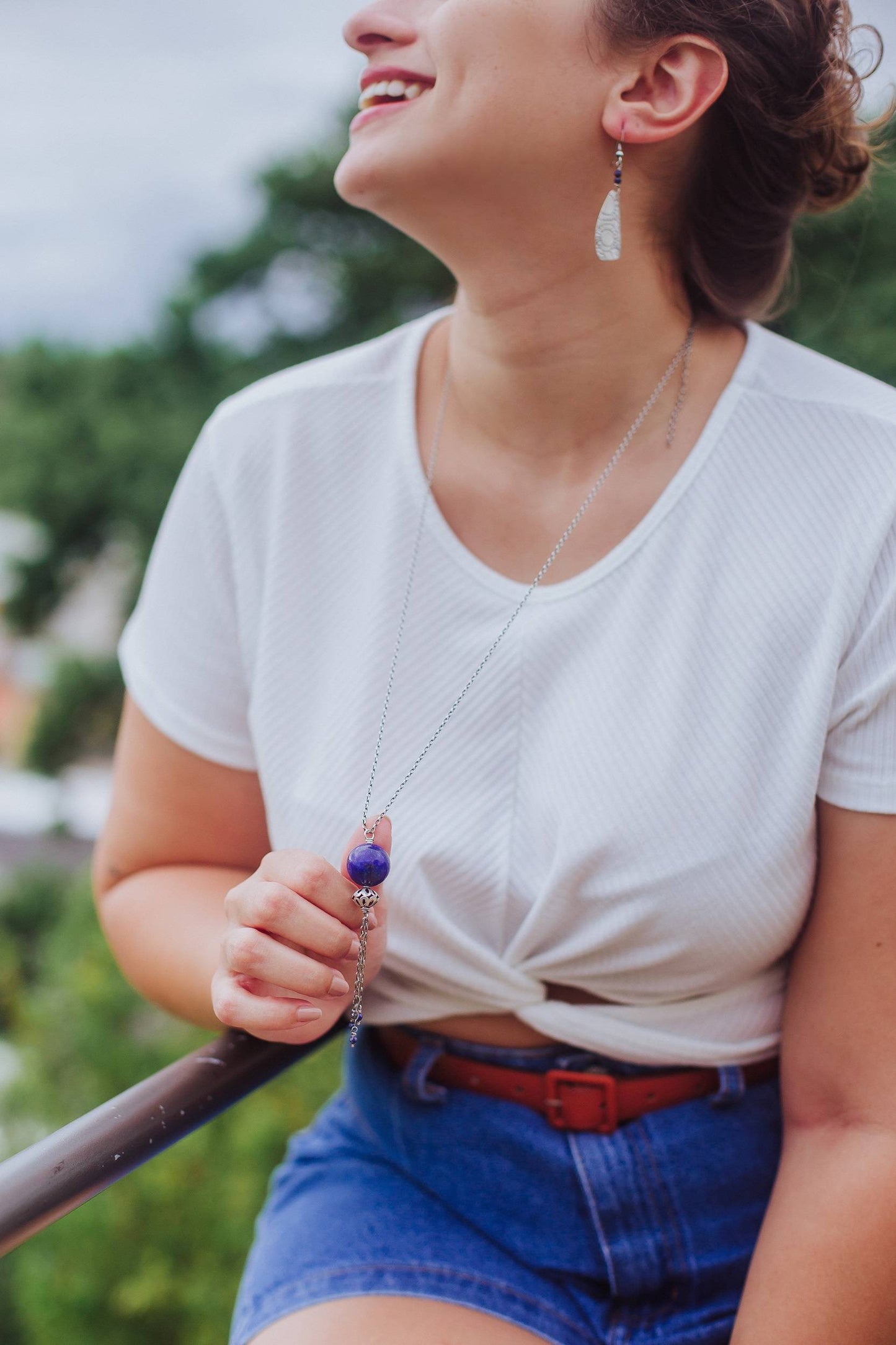 Ce bijou unique est un collier long, sans fermoir, réalisé en argent 925. Il est orné d'un pendentif en lapis-lazuli, une pierre naturelle bleue profonde. La longueur totale du collier est de 90 centimètres.